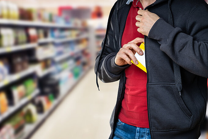 Mann, der im Supermarkt stiehlt